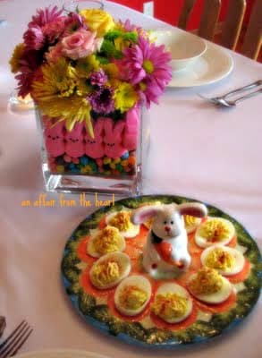 A Peep centerpiece and a bunny deviled egg plate on a white table cloth.