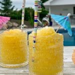 Side view of Frozen Vodka Slush with an umbrella and straw in it