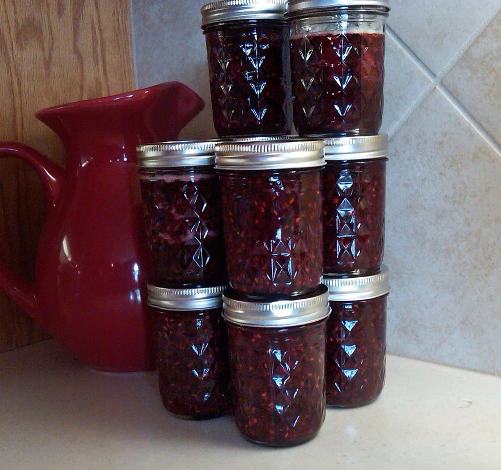 Berry preserve in jars stacked on a counter