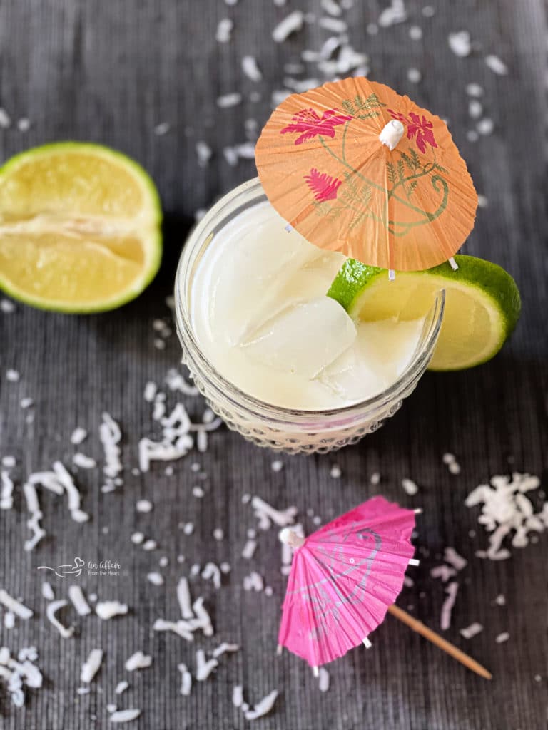 Overhead of Mini Vacation - aka Brazilian Lemonade Cocktails garnished with limes and cocktail umbrellas