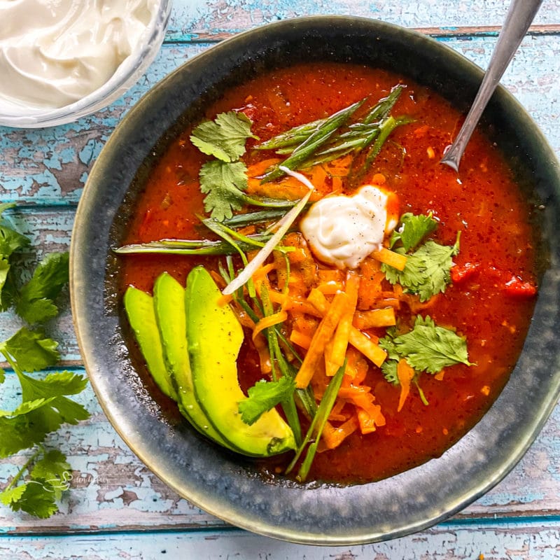 serving tortilla soup in a ceramic bowl