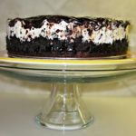 Side view of cookies and cream ice cream cake on a cake stand