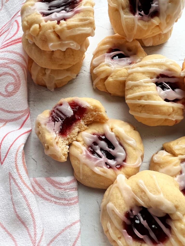 Almond Raspberry Shortbread Thumbprint Cookies white background with pink and white tea towel