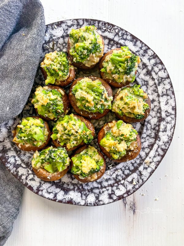 one plate of stuffed mushrooms with broccoli 