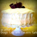 Side view of Orange Layer cake onn a white cake platter with text "orange cake with chocolate curls"