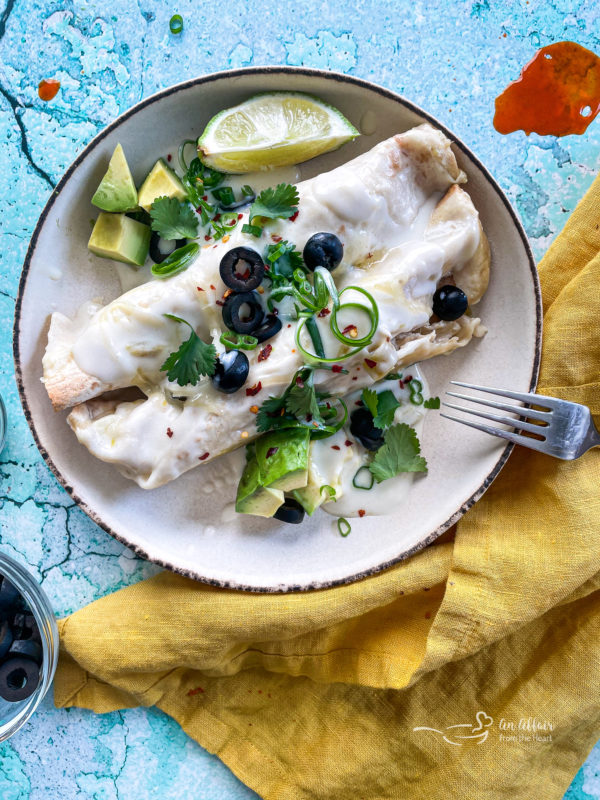 Two enchiladas on plate with fork