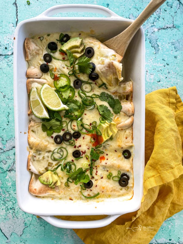 Top view of white chicken enchiladas in white dish 