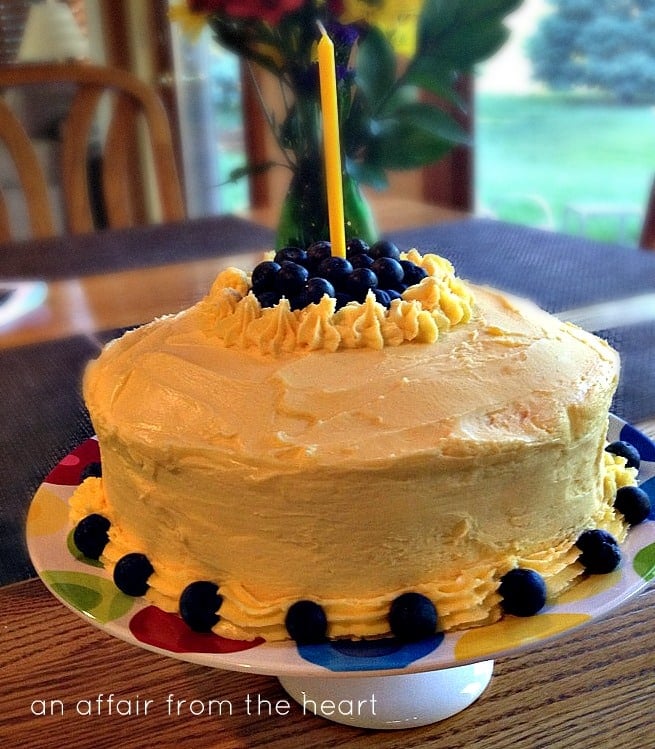 Overhead of Lemonade Cake with Blueberry filling and lemonade butter cream frosting with a candle in it