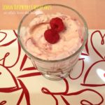 overhead of cheesecake in a glass with text "lemon raspberry cheesecakes"