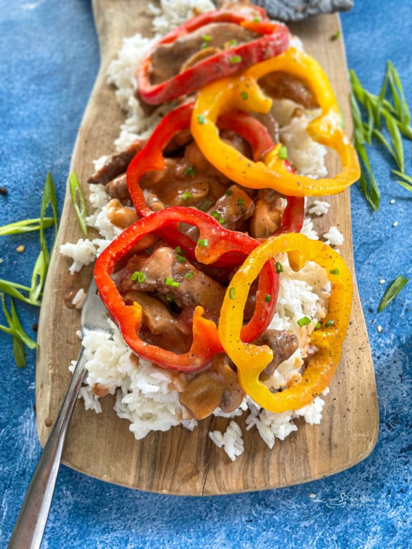 Pepper steak with rice and colorful peppers on plate