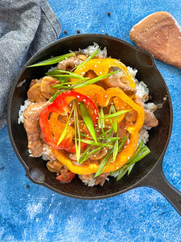 Top view of pepper steak in pan with veggies