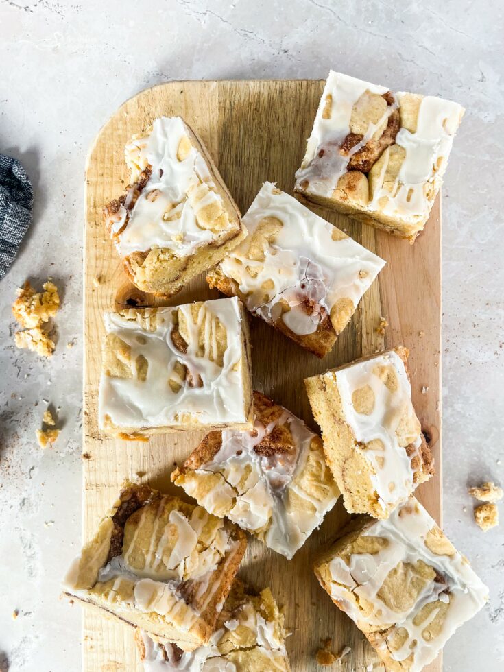 Iced snickerdoodle cookie bars on a wood board