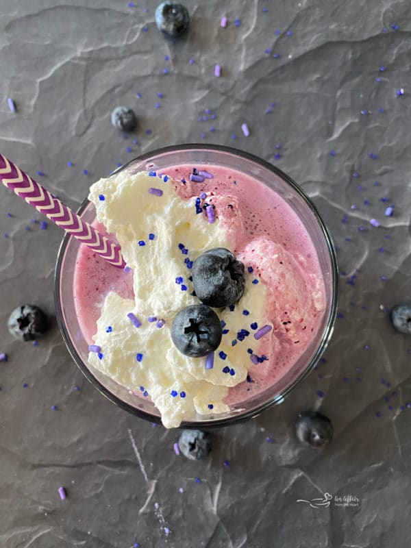 Top view of smoothie with straw and blueberries