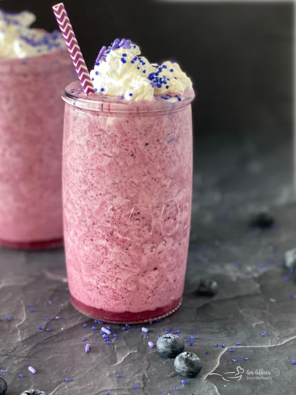 Front view of purple cow smoothie topped with ice cream and sprinkles