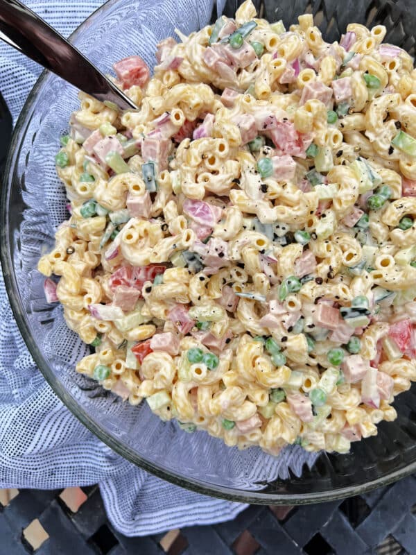 Close up of pasta salad with spam in a clear bowl.