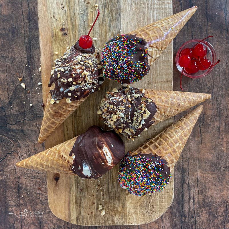 Five chocolate dipped cones with nuts and cherries