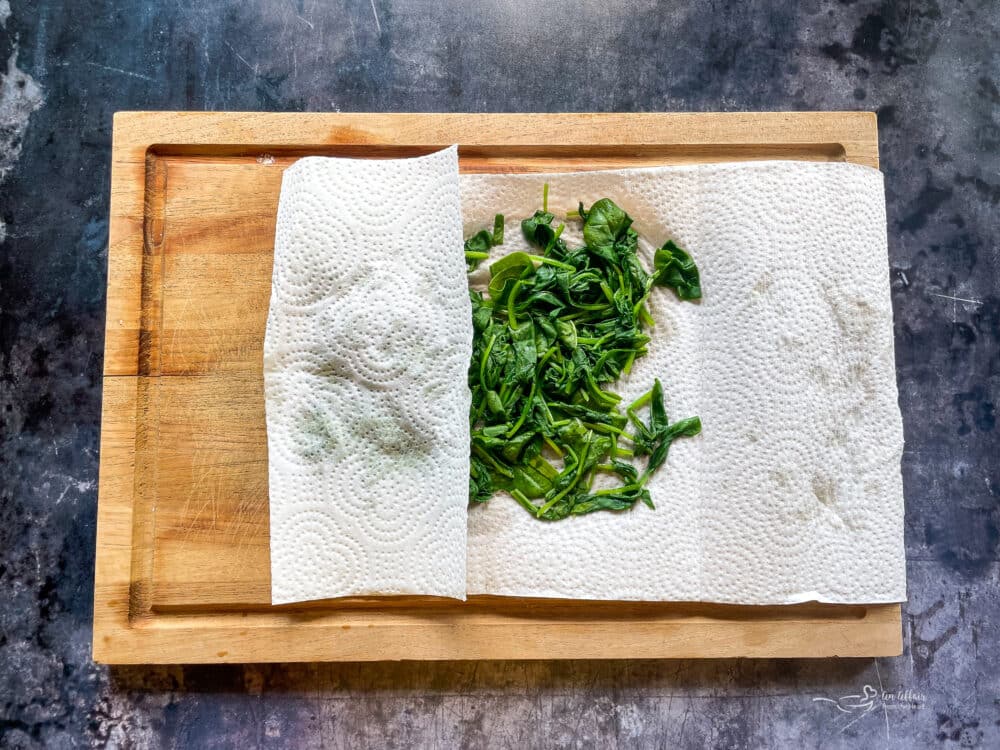 Remove the spinach and place it on a paper towel, pat all of the liquid out of the spinach.