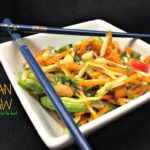 Asian Slaw in a white square bowl with chopsticks laying on top and text
