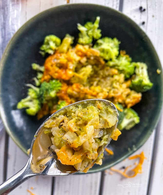Close up view of broccoli and cheese casserole in a spoon