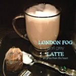 London Fog inn a clear mug, a spoon and a used tea bag all on a black surface. Text "London Fog earl grey Latte"