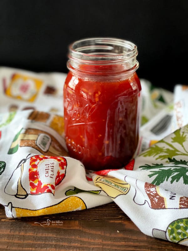 Homemade BBQ Sauce in a jar on a multi-colored cloth