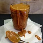 caramel sauce in a jar and dripping off the sides on to parchment paper with a spoon covered in the sauce. Text "homemade salted caramel sauce"