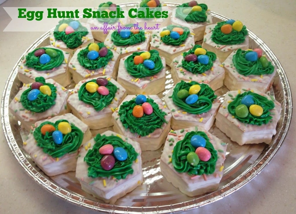 Little Debbie Snack Cakes decorated with grass like frosting and mini Easter egg candies on a silver platter