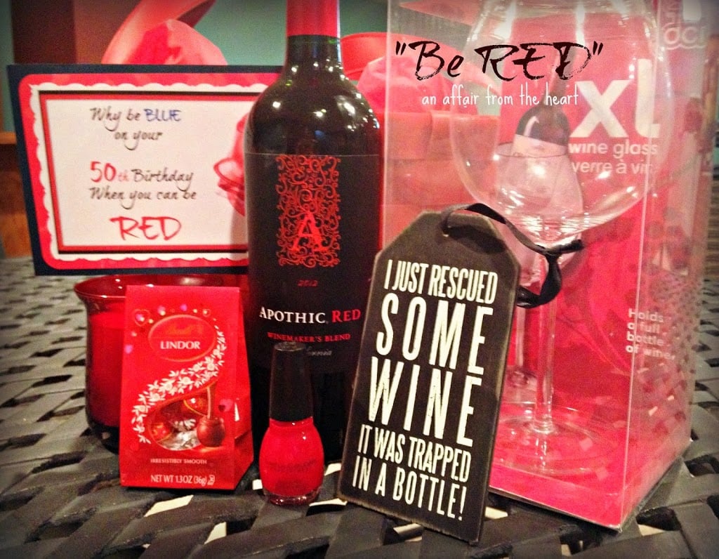 Red wine, red candy, red nail polish and wine glasses on a black table