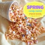 spring candy coated popcorn falling out of a white popcorn bowl on to white cloth. text "Spring Candy coated popcorn"