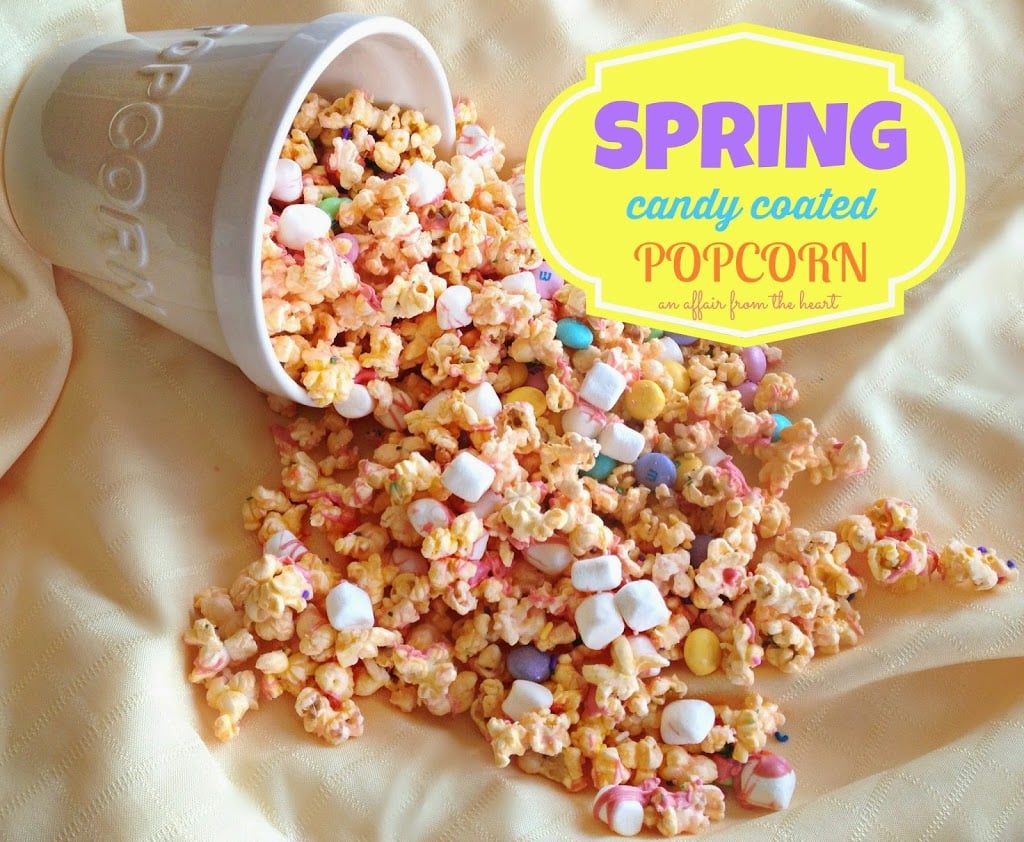 spring candy coated popcorn falling out of a white popcorn bowl on to white cloth. text "Spring Candy coated popcorn"