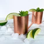 Side view of 2 Moscow Mule cocktail in a copper mug.