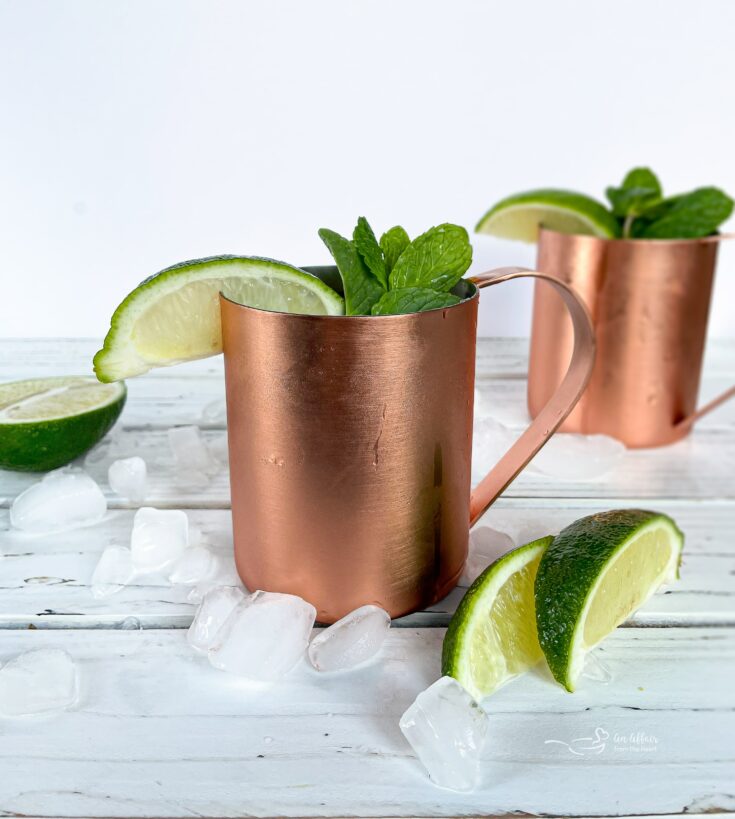 Side view of 2 Moscow Mule cocktail in a copper mug.