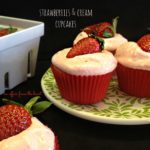 strawberries and cream cupcakes on a plate with leaves on it