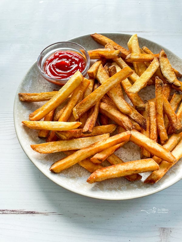 Front view of fries on plate with ketchup