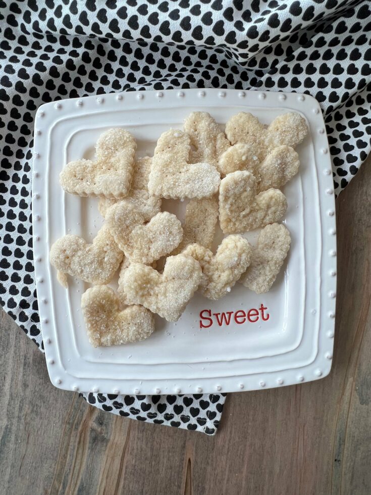 Heart shaped pie crust cookies on a white, square dish.