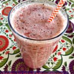 Overhead of smoothie with text "raspberry and peach superfood smoothie"