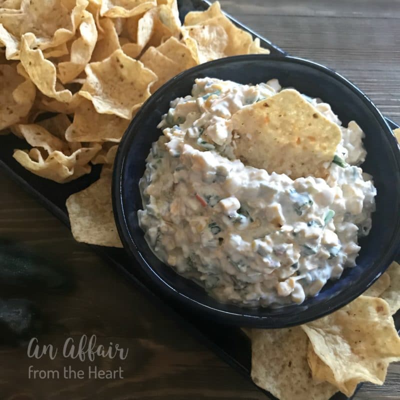 Close up of {Award Winning} Crack Dip in a black bowl with chips around it
