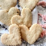 heart shaped lavender shortbread stacked on a white cloth.