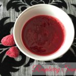 overhead of raspberry sauce in a white cup