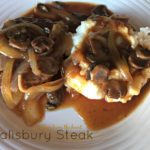 overhead of salisbury steak with mushrooms and mashed potatoes on a white plate