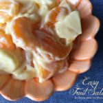Close up of fruit salad in a coral serving bowl with text "easy fruit salad"