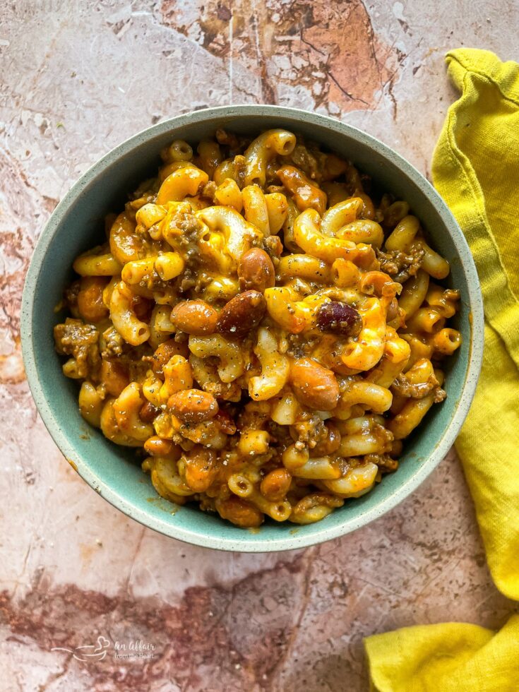 Chili Mac in a bowl with a yellow napkin along the side