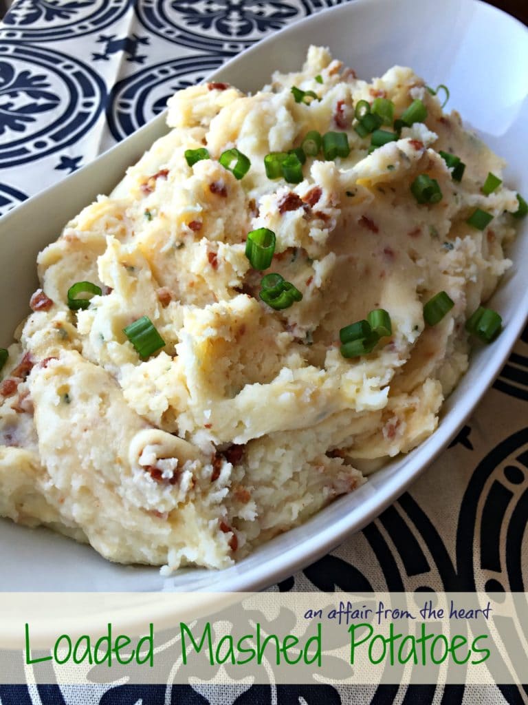 Potatoes in a white serving dish with text "Loaded Mashed Potatoes"