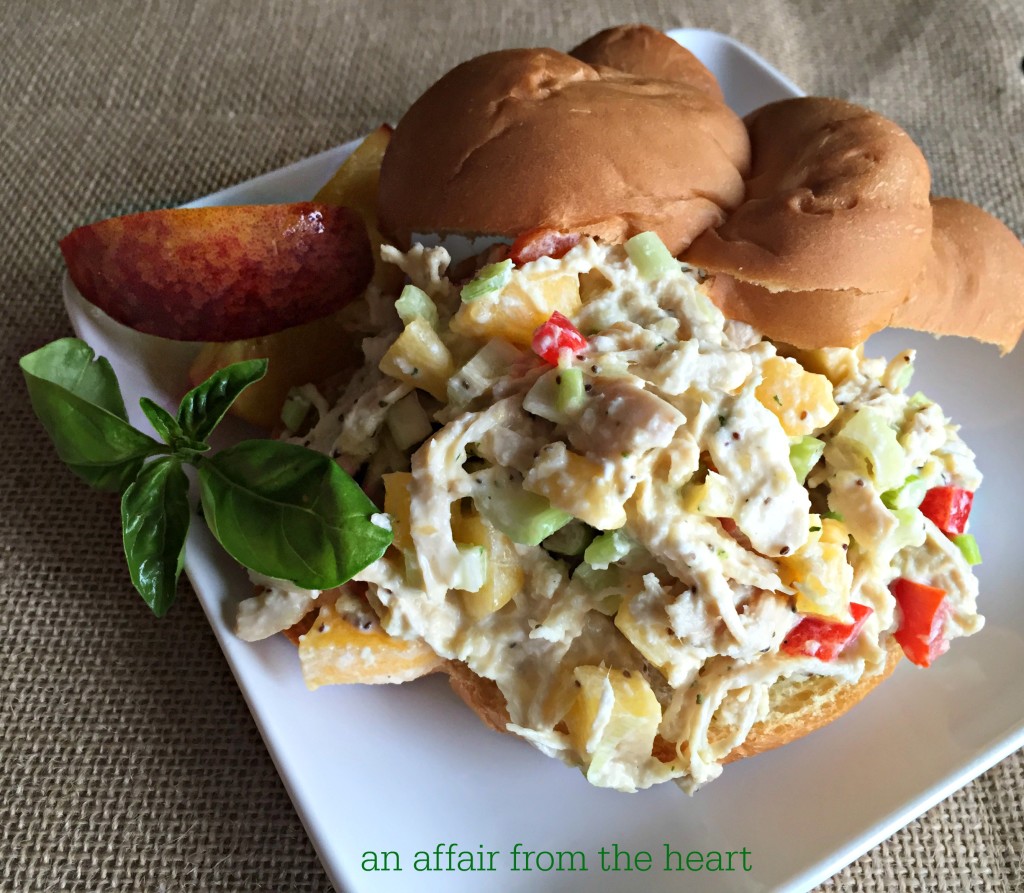 Peach Basil Chicken Salad on white plate with bun