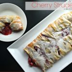 Overhead of strudel on a white serving tray and a slice on a white plate with text "cherry strudel"
