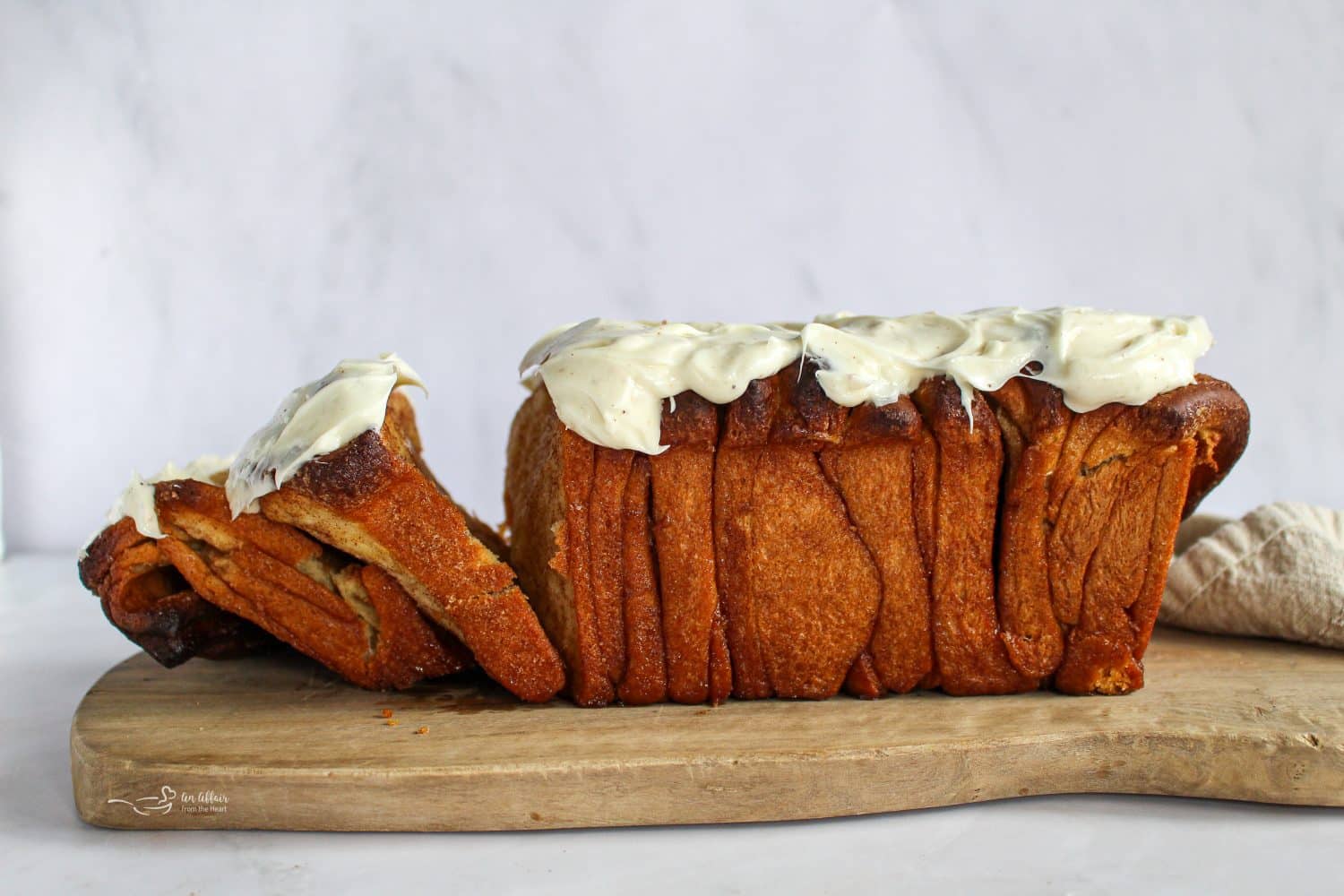 Side view of cinnamon pull apart bread on a wooden board