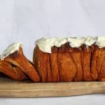 Side view of cinnamon pull apart bread on a wooden board