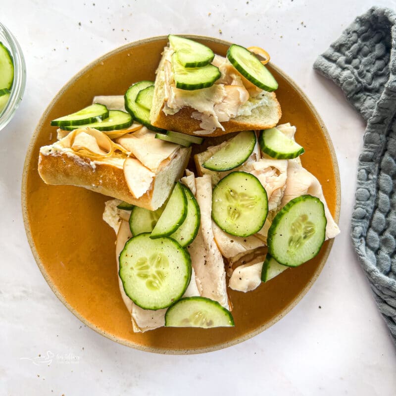 Sliced turkey ranch baguettes on a wood plate