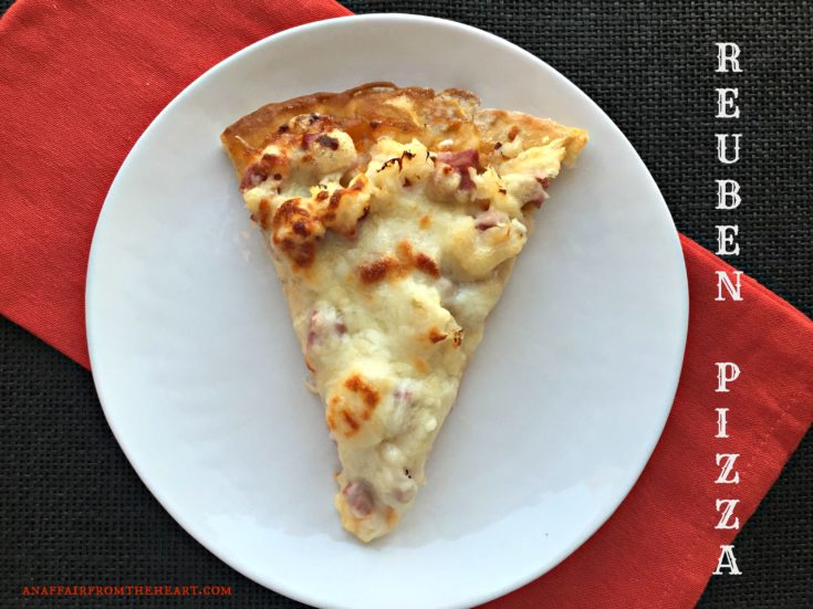 Slice of Reuben Pizza on a white plate
