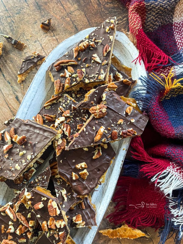 graham cracker toffee pieces on white oval plate with pecans